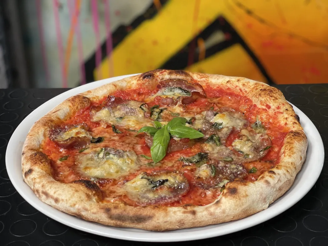 Pizza tomate, pancetta, parmesan râpé, huile d'ail, poivre, basilic frais