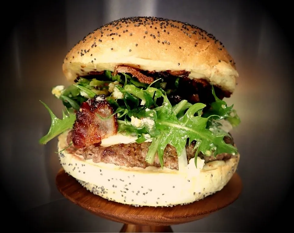 Burger Mamouchka : Bun boulanger, steak Beefore (bœuf/veau CH, 150g), dent de lion et vinaigrette Mamouchka (œuf/moutarde à l'ancienne), bacon grillé, gorgonzola doux, mayo maison moutarde/miel