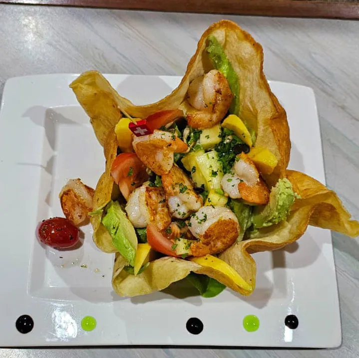 Ceviche de poisson blanc mariné aux citrons, servi avec une salade et sa sauce "al peperoncino", frites