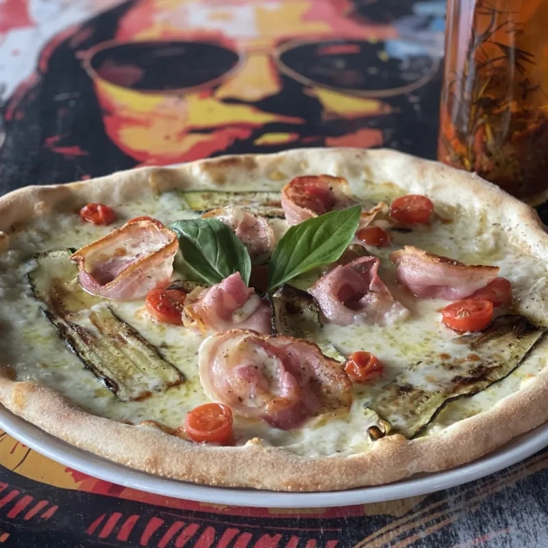 Pizza mozzarella, courgettes, tomates cerises, pancetta, poivre, basilic frais