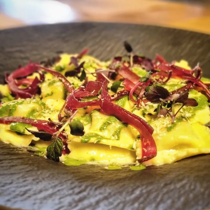 Raviole à l'ail des ours, crème de parmesan, coulis de persil, viande des Grisons